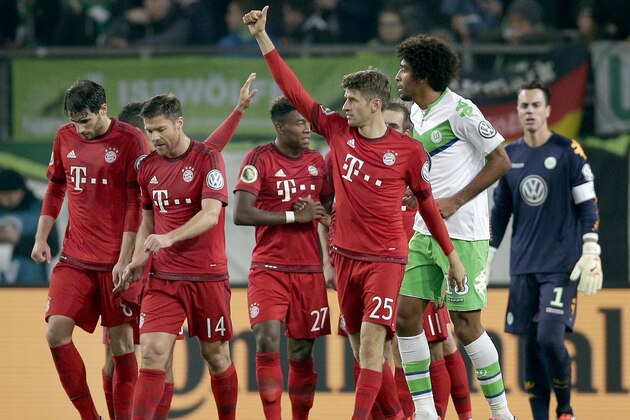 Bayern's Thomas Mueller, front, gives a thumb up as he celebrates scoring his side's third goal during the German soccer cup second round match between VfL Wolfsburg and FC Bayern Munich in Wolfsburg, Germany, Tuesday, Oct. 27, 2015. (AP Photo/Michael Sohn)