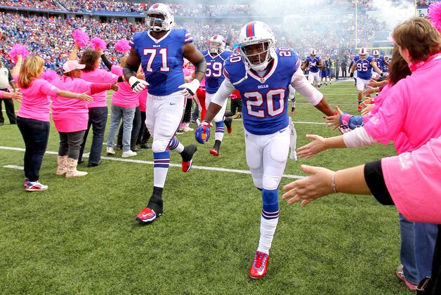 Buffalo Bills free safety Corey Graham (20) and tackle Cyrus Kouandjio (71) run near women wearing pink in observance of Breast Cancer Awareness Month prior to an NFL football game against the New York Giants, Sunday, Oct. 4, 2015, in Orchard Park, N.Y. (AP Photo/Bill Wippert)