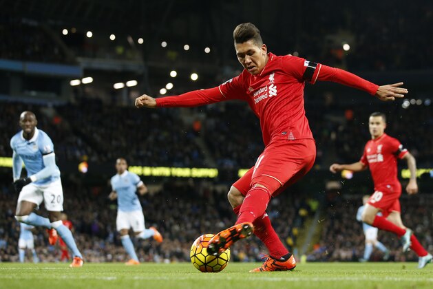 Liverpool’s Roberto Firmino crosses the ball which is then turned in by Manchester City's Eliaquim Mangala, no 20 left, who scores an own goal for the opening goal of the game during the English Premier League soccer match between Manchester City and Liverpool at the Etihad Stadium, Manchester, England, Saturday, Nov. 21, 2015. (AP Photo/Jon Super)