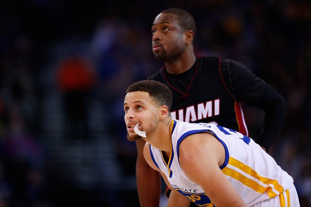 OAKLAND, CA - JANUARY 11:  Stephen Curry #30 of the Golden State Warriors and Dwyane Wade #3 of the Miami Heat watch a free throw being shot at ORACLE Arena on January 11, 2016 in Oakland, California. NOTE TO USER: User expressly acknowledges and agrees that, by downloading and or using this photograph, User is consenting to the terms and conditions of the Getty Images License Agreement.  (Photo by Ezra Shaw/Getty Images)