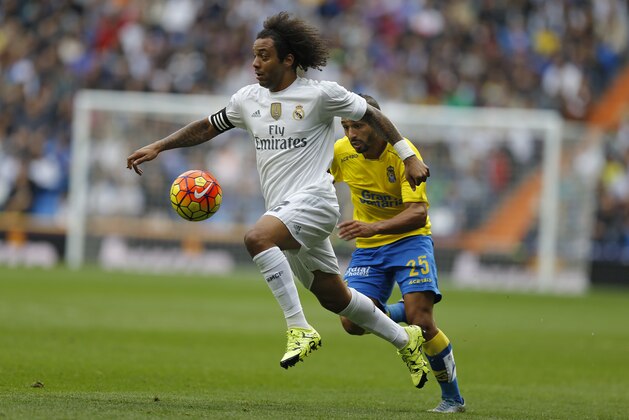 Real Madrid's Marcelo, left, runs with the ball past Las Palmas' Nabil El Zhar during the Spanish La Liga soccer match between Real Madrid and Las Palmas at the Santiago Bernabeu stadium in Madrid, Saturday, Oct. 31, 2015. Real Madrid won 3-1. (AP Photo/Francisco Seco)