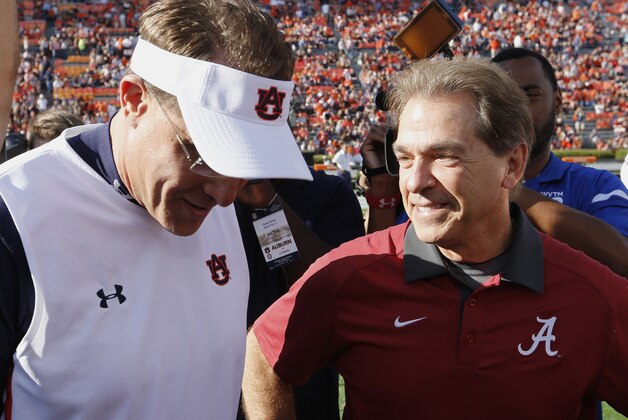 Alabama head coach Nick Saban, right, and Auburn head coach Gus Malzahn meet before a NCAA college football game, Saturday, Nov. 28, 2015, in Auburn, Ala. (AP Photo/Butch Dill)