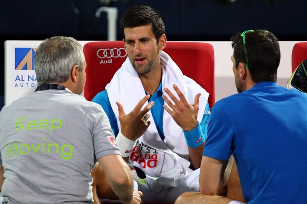 Serbian Novak Djokovic (C) receives medical attention during a break in his ATP quarterfinal tennis match against Spain's Feliciano Lopez during the Dubai Duty Free Tennis Championships February 25, 2016. / AFP / MARWAN NAAMANI        (Photo credit should read MARWAN NAAMANI/AFP/Getty Images)