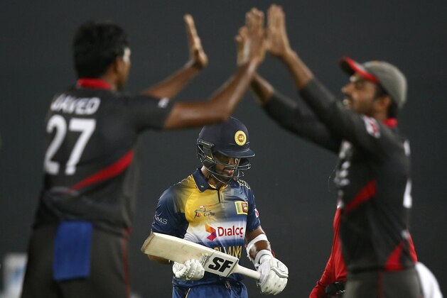 United Arab Emirates’ captain, Amjad Javed, left, celebrates with teammate Shaiman Anwar, right, after the dismissal of Sri Lanka’s Dinesh Chandimal, center,  during their Asia Cup Twenty20 international cricket match in Dhaka, Bangladesh, Thursday, Feb. 25, 2016. (AP Photo/A.M. Ahad)