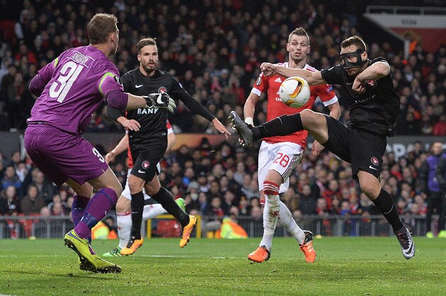 FC Midtjylland's Danish goalkeeper Mikkel Andersen (L) watches as FC Midtjylland's Bulgarian defender Nikolay Bodurov (R) clears the ball from the path of Manchester United's French midfielder Morgan Schneiderlin during the UEFA Europa League round of 32, second leg football match between Manchester United and and FC Midtjylland at Old Trafford in Manchester, north west England, on February 25, 2016.  / AFP / OLI SCARFF        (Photo credit should read OLI SCARFF/AFP/Getty Images)