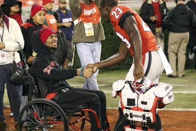 FILE - In this Nov. 21, 2015, file photo, injured Southern University receiver Devon Gales is greeted by Georgia wide receiver Shakenneth Williams (23) before an NCAA college football game between Georgia and Georgia Southern, in Athens, Ga. Gales, the Southern player who suffered a paralyzing neck injury in a game against Georgia, finally is headed home to Louisiana. (AP Photo/John Bazemore, File)