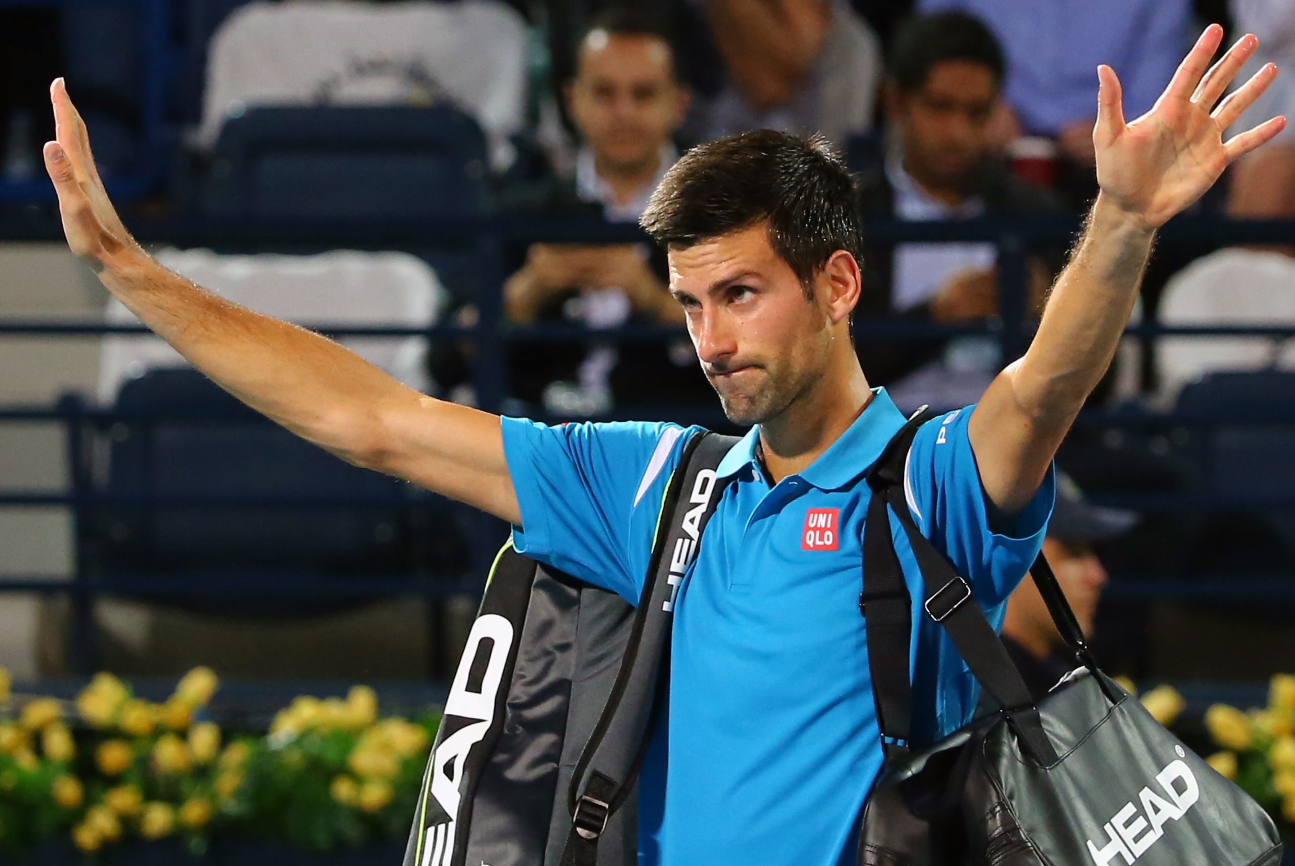 Serbian Novak Djokovic gestures to the crowd as walks off the court after his withdrawal from the ATP quarterfinal tennis match against Spain's Feliciano Lopez during the Dubai Duty Free Tennis Championships February 25, 2016. / AFP / MARWAN NAAMANI        (Photo credit should read MARWAN NAAMANI/AFP/Getty Images)