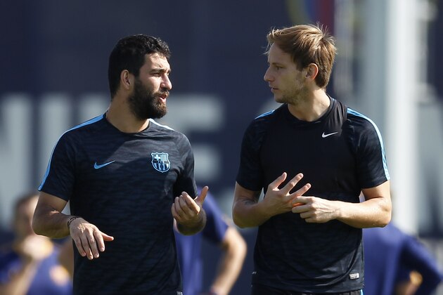FC Barcelona's Arda Turan, left, talks with his teammate Ivan Rakitic during a training session at the Sports Center FC Barcelona Joan Gamper in San Joan Despi, Spain, Monday, Sept. 28, 2015.  FC Barcelona will play against Bayer Leverkusen during a Champions League Group E on Tuesday . (AP Photo/Manu Fernandez)