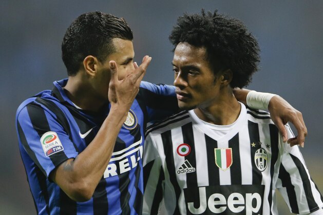 Inter Milan’s Jeison Murillo, left, hugs Juventus' Juan Cuadrado at the end of  a Serie A soccer match between Inter Milan and Juventus at the San Siro stadium in Milan, Italy, Sunday, Oct. 18, 2015. The match ended 0-0. (AP Photo/Luca Bruno)