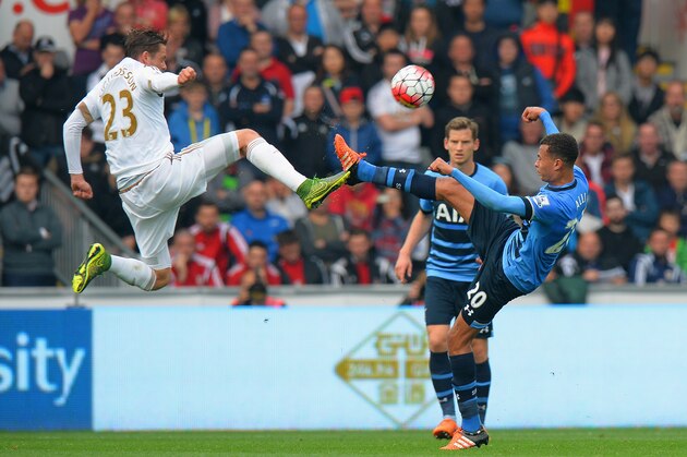 SWANSEA, WALES - OCTOBER 04: Gylfi Sigurdsson of Swansea City challenges Dele Alli of Tottenham Hotspur during the Barclays Premier League match between Swansea City and Tottenham Hotspur at Liberty Stadium on October 4, 2015 in Swansea, Wales.  (Photo by Tony Marshall/Getty Images)
