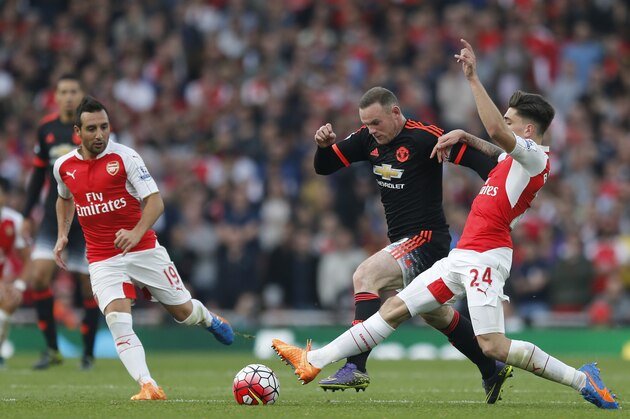 Manchester United's Wayne Rooney,left, is tackled by Arsenal's Hector Bellerin during the English Premier League soccer match between Arsenal and Manchester United at Emirates stadium in London, Sunday, Oct. 4, 2015.(AP Photo/Frank Augstein)