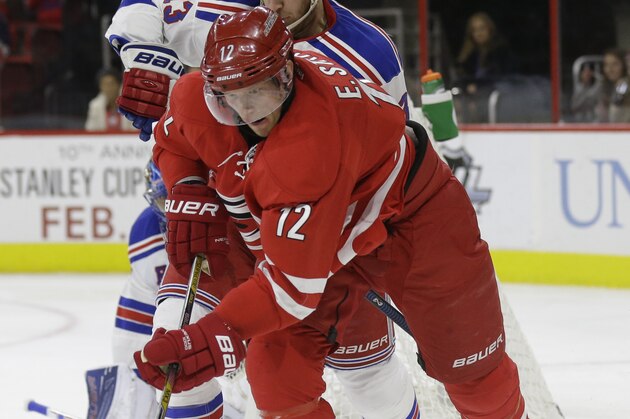 Carolina Hurricanes' Eric Staal (12) and New York Rangers' Kevin Hayes (13) chase the puck during the second period of an NHL hockey game in Raleigh, N.C., Friday, Jan. 22, 2016. (AP Photo/Gerry Broome)