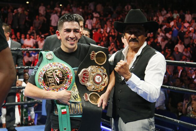 Leo Santa Cruz celebrates with his belts after he was announced the winner against Abner Mares in their WBC diamond featherweight and WBA featherweight championship boxing bout, Saturday, Aug. 29, 2015, in Los Angeles. (AP Photo/Danny Moloshok)