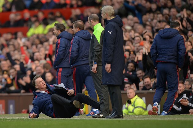 Manchester United's Dutch manager Louis van Gaal (L) falls over on the touchline in front of fourth official Mike Dean (3R) and Arsenal's French manager Arsene Wenger (2R) during the English Premier League football match between Manchester United and Arsenal at Old Trafford in Manchester in north west England on February 28, 2016. / AFP / OLI SCARFF / RESTRICTED TO EDITORIAL USE. No use with unauthorized audio, video, data, fixture lists, club/league logos or 'live' services. Online in-match use limited to 75 images, no video emulation. No use in betting, games or single club/league/player publications.  /         (Photo credit should read OLI SCARFF/AFP/Getty Images)