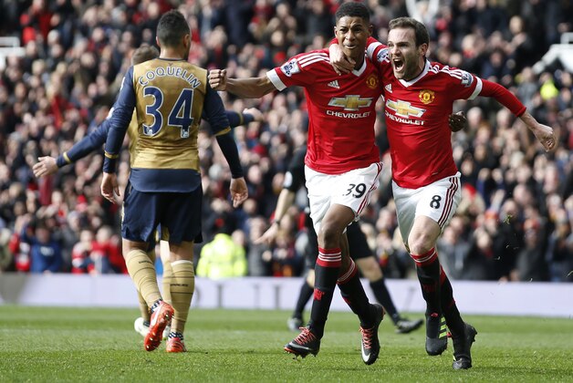 Manchester United's Marcus Rashford, left celebrates with teammate Juan Mata after he sores the opening goal of the game during the English Premier League soccer match between Manchester United and Arsenal at Old Trafford Stadium, Manchester, England, Sunday, Feb. 28, 2016. (AP Photo/Jon Super)