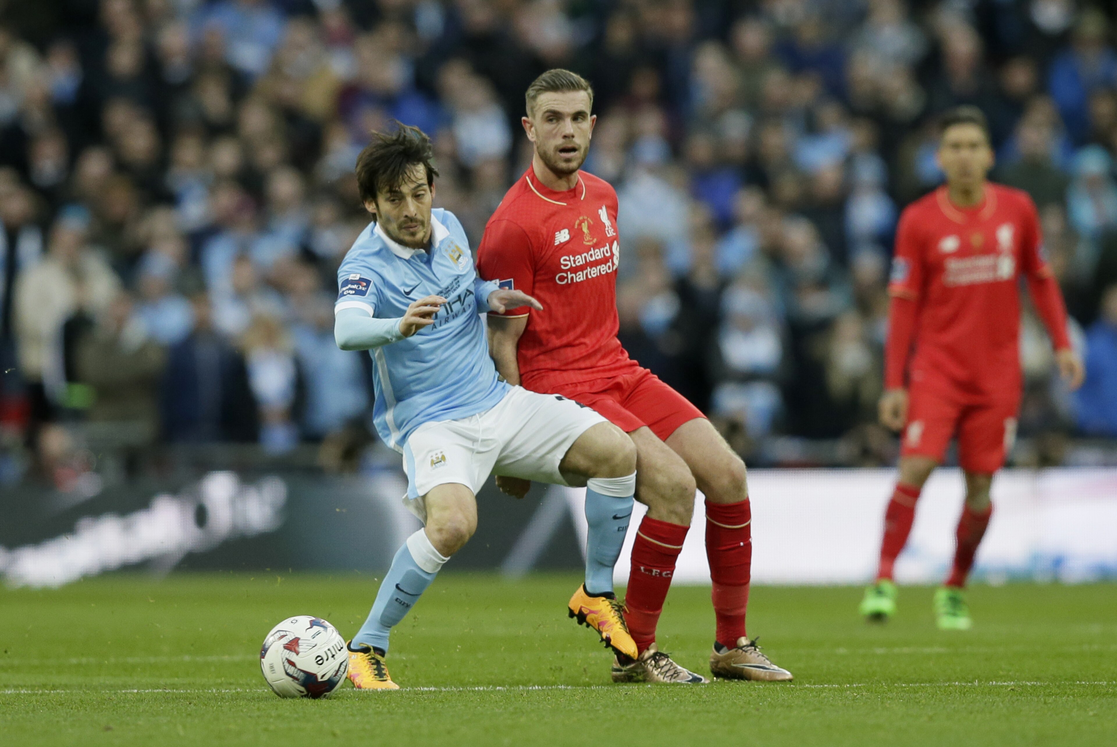Manchester City's David Silva, left, competes for the ball with Liverpool's Jordan Henderson during the English League Cup final soccer match between Liverpool and Manchester City at Wembley stadium in London, Sunday, Feb. 28, 2016. (AP Photo/Tim Ireland)
