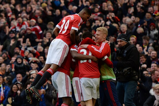 Manchester United's English striker Marcus Rashford (L) joins the celebration after Manchester United's Spanish midfielder Ander Herrera scored their third goal during the English Premier League football match between Manchester United and Arsenal at Old Trafford in Manchester in north west England on February 28, 2016. / AFP / OLI SCARFF / RESTRICTED TO EDITORIAL USE. No use with unauthorized audio, video, data, fixture lists, club/league logos or 'live' services. Online in-match use limited to 75 images, no video emulation. No use in betting, games or single club/league/player publications.  /         (Photo credit should read OLI SCARFF/AFP/Getty Images)