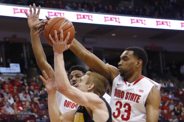 Iowa's Mike Gesell, center, has his shot blocked by Ohio State's Keita Bates-Diop, right, as JaQuan Lyle defends during the first half of an NCAA college basketball game Sunday, Feb. 28, 2016, in Columbus, Ohio. (AP Photo/Jay LaPrete)
