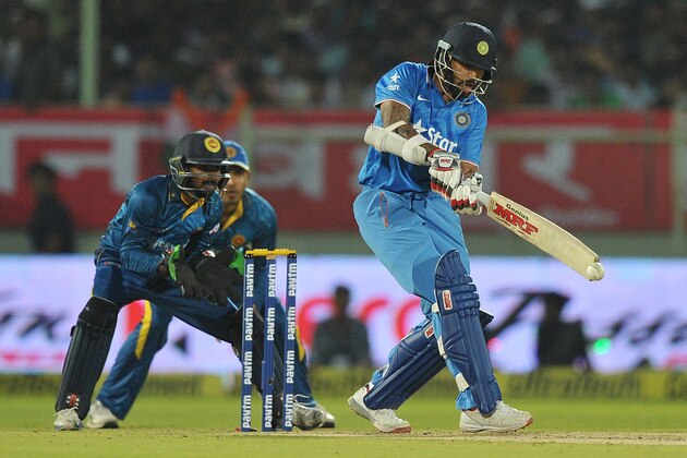 India's Shikhar Dhawan (R) plays a shot as Sri Lankan captain and wicketkeeper Dinesh Chandimal (C) looks on during the third T20 international cricket match between India and Sri Lanka at the Dr. Y.S. Rajasekhara Reddy ACA-VDCA Cricket Stadium in Visakhapatnam on February 14, 2016.  AFP PHOTO / Noah SEELAM  ---- IMAGE RESTRICTED TO EDITORIAL USE - STRICTLY NO COMMERCIAL USE ---- / AFP / NOAH SEELAM        (Photo credit should read NOAH SEELAM/AFP/Getty Images)