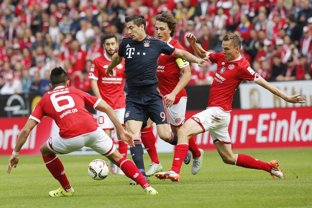 Bayern's Robert Lewandowski, center, and Mainz's Pablo de Blasis, right, challenge for the ball during a German Bundesliga soccer match between FSV Mainz 05 and Bayern Munich in Mainz, Germany, Saturday, Sept. 26, 2015. (AP Photo/Michael Probst)