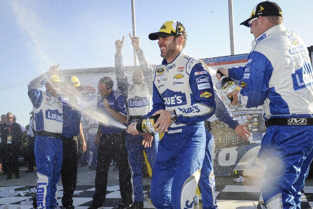 Jimmie Johnson, second from right, celebrates with team members after winning a NASCAR Sprint Cup Series auto race at Atlanta Motor Speedway, Sunday, Feb. 28, 2016, in Hampton, Ga. (AP Photo/John Amis)