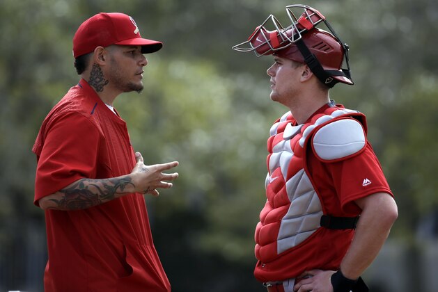 St. Louis Cardinals catcher Yadier Molina, left, talks with fellow catcher Carson Kelly during spring training baseball practice Sunday, Feb. 21, 2016, in Jupiter, Fla. (AP Photo/Jeff Roberson)
