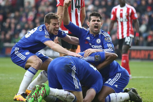 Chelsea's Brazilian-born Spanish striker Diego Costa (R top) and Chelsea's Spanish defender Cesar Azpilicueta (top L) join the celebration after Chelsea's Serbian defender Branislav Ivanovic (C floor obscured) scored their second goal during the English Premier League football match between Southampton and Chelsea at St Mary's Stadium in Southampton, southern England on February 27, 2016. / AFP / JUSTIN TALLIS / RESTRICTED TO EDITORIAL USE. No use with unauthorized audio, video, data, fixture lists, club/league logos or 'live' services. Online in-match use limited to 75 images, no video emulation. No use in betting, games or single club/league/player publications.  /         (Photo credit should read JUSTIN TALLIS/AFP/Getty Images)