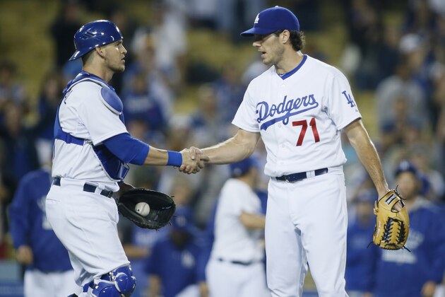 Los Angeles Dodgers catcher Yasmani Grandal, left, and relief pitcher Josh Ravin, right, celebrate after the Dodgers defeated the Arizona Diamondbacks 9-3 in a baseball game, Monday, June 8, 2015, in Los Angeles. (AP Photo/Danny Moloshok)