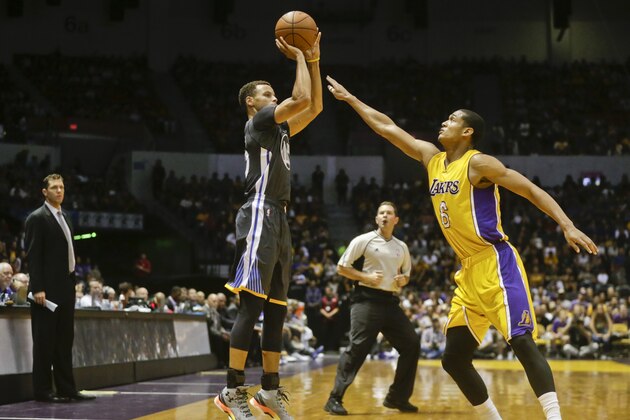 Golden State Warriors guard Stephen Curry makes a three point shot over the defense of Los Angeles Lakers guard Jordan Clarkson in the first half of an NBA preseason basketball game Saturday, Oct. 17, 2015, in San Diego.  (AP Photo/Lenny Ignelzi)
