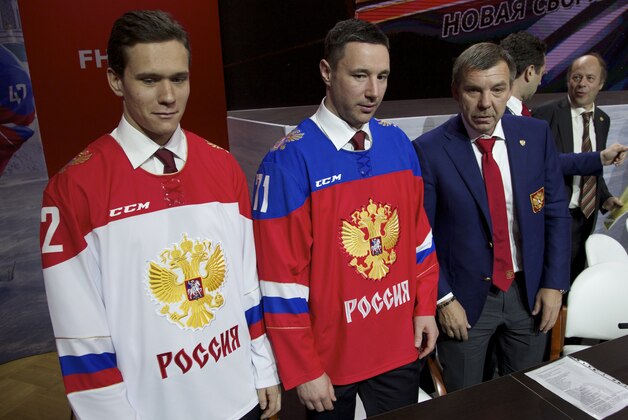 From left, Russian ice hockey players, Nikita Zaitsev, Ilya Kovalchuk and national team coach Oleg Znarok present the team's new jerseys for the coming season during a news conference in Moscow, Russia, Friday, Oct. 30, 2015. Russia will host the 2016 Ice hockey World Cup, sharing it between two cities, Moscow and St.Petsrburg. (AP Photo/Ivan Sekretarev)