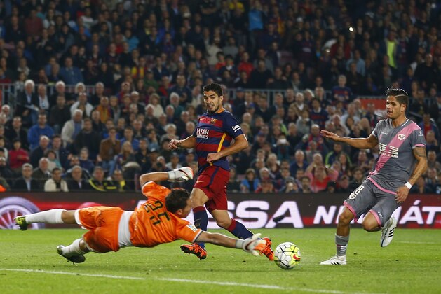 FC Barcelona's Luis Suarez, second left, kicks the ball for scores against Rayo Vallecano's goalkeeper Tono Martinez during a Spanish La Liga soccer match at the Camp Nou stadium in Barcelona, Spain, Saturday, Oct. 17, 2015. (AP Photo/Manu Fernandez)