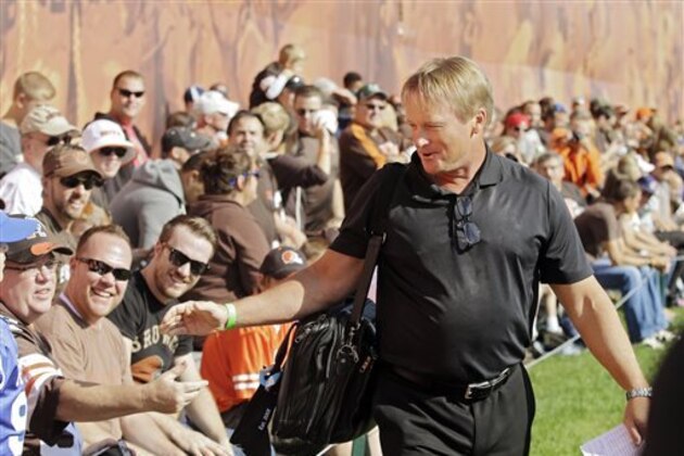 FILE - In this Aug. 15, 2014, file photo, former NFL coach and current ESPN analyst Jon Gruden greets fans at the Cleveland Browns football training camp in Berea, Ohio. The future of youth sports makes Jon Gruden cringe. The Super Bowl-winning coach and ESPN football analyst is part of a program aimed at repairing fields and buying uniforms and equipment. More needs to be done, Gruden says, particularly in low-income areas.  (AP Photo/Mark Duncan, File)