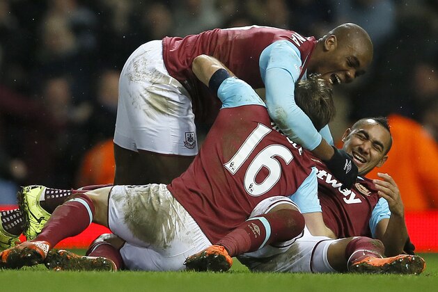 West Ham's Angelo Ogbonna, top, celebrates scoring the winning goal during the English FA Cup fourth round replay soccer match between West Ham United and Liverpool at the Boleyn Ground stadium in London, Tuesday, Feb. 9, 2016. (AP Photo/Kirsty Wigglesworth)
