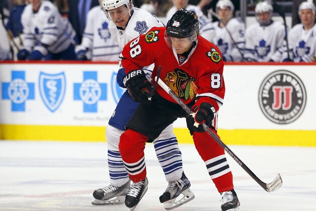 Chicago Blackhawks right wing Patrick Kane (88) battles Toronto Maple Leafs left wing Colin Greening (38) during the first period of an NHL hockey game on Monday, Feb. 15, 2016, in Chicago. (AP Photo/Jeff Haynes)