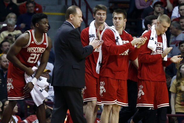 Wisconsin interi coach Greg Gard and his players applaud a play duirng the second half of an NCAA college basketball game against Minnesota, Wednesday, March 2, 2016, in Minneapolis. Wisconsin won 62-49. (AP Photo/Jim Mone)