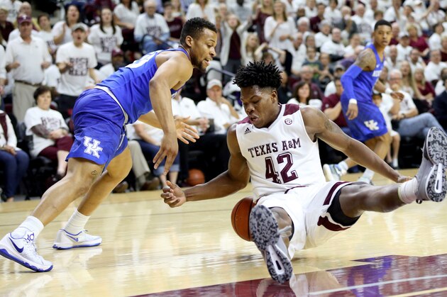Texas A&M's Tavario Miller (42) looses his balance while going after a loos ball against Kentucky's Isaiah Briscoe (13)  during the first half of an NCAA college basketball game, Saturday, Feb. 20, 2016, in College Station, Texas. (AP Photo/Sam Craft)