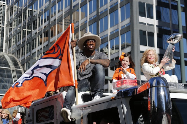 Super Bowl MVP and Denver Broncos linebacker Von Miller holds a Denver Broncos flag while Annabel Bowlen, wife of Denver Broncos owner Pat Bolwen hoists the Lombardi Trophy during a parade for the NFL football Super Bowl champions, Tuesday, Feb. 9, 2016, in Denver. (AP Photo/Jack Dempsey)