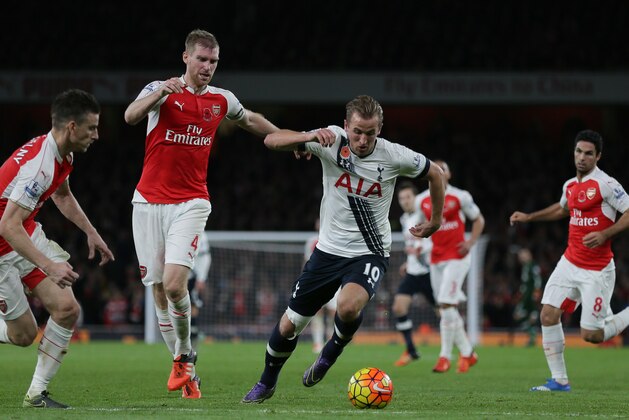Tottenham’s Harry Kane, right, makes a late break from Arsenal’s Per Mertesacker, second left, and Laurent Koscielny during the English Premier League soccer match between Arsenal and Tottenham Hotspur at the Emirates Stadium in London, Sunday Nov. 8, 2015. (AP Photo/Tim Ireland)
