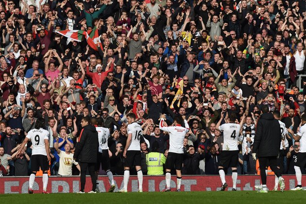 Manchester United players celebrate their victory with their supporters after the English Premier League football match between Liverpool and Manchester United at Anfield in Liverpool, north west England on March 22, 2015. Manchester United won the game 2-1. AFP PHOTO / PAUL ELLIS

RESTRICTED TO EDITORIAL USE. NO USE WITH UNAUTHORIZED AUDIO, VIDEO, DATA, FIXTURE LISTS, CLUB/LEAGUE LOGOS OR LIVE SERVICES. ONLINE IN-MATCH USE LIMITED TO 45 IMAGES, NO VIDEO EMULATION. NO USE IN BETTING, GAMES OR SINGLE CLUB/LEAGUE/PLAYER PUBLICATIONS.        (Photo credit should read PAUL ELLIS/AFP/Getty Images)