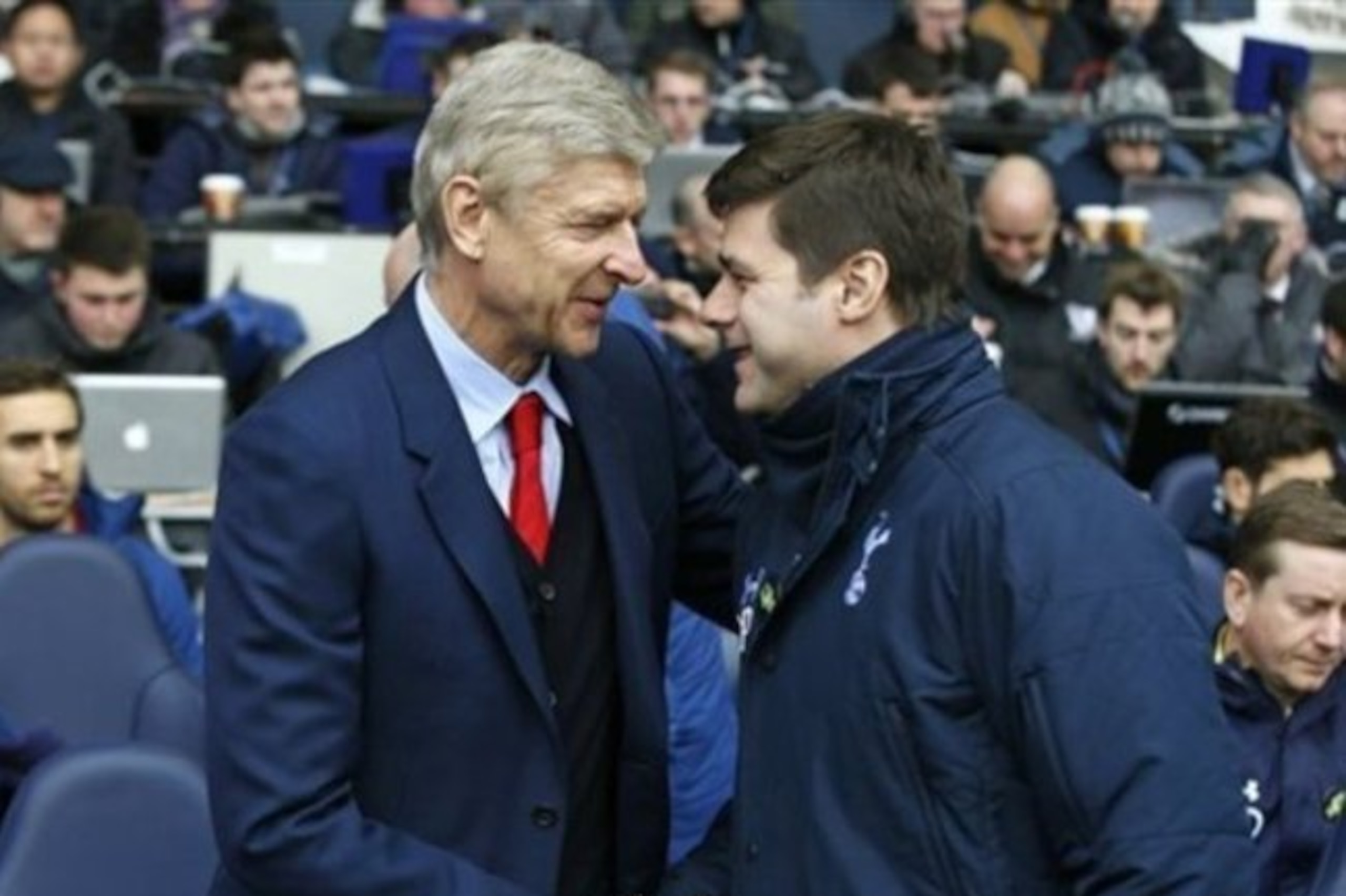 Arsenal's head coach Arsene Wenger, left, shakes hands with Tottenham’s manager Mauricio Pochettino before the English Premier League soccer match between Tottenham Hotspur and Arsenal at the White Hart Lane stadium in London, Saturday, Feb. 7, 2015. (AP Photo/Alastair Grant)
