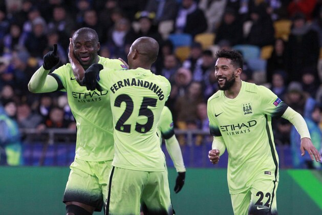 Manchester City's Yaya Toure, left, celebrates with teammates Fernandinho, center, and Gael Clichy, right, after scoring his side third goal during the Champions League round of 16 first leg soccer match between Dynamo Kiev and Manchester City at the Olympiyskiy stadium in Kiev, Ukraine, Wednesday, Feb. 24, 2016.  (AP Photo/Sergei Chuzavkov)