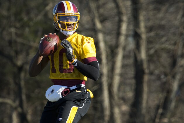 FILE - In this Jan. 6, 2016 file photo, Washington Redskins quarterback Robert Griffin III eyes the receiver during NFL football practice at Redskins Park in Ashburn, Va. Griffin has cleared out his locker at Redskins Park and is expected to be let go by the team that dealt a trove of draft picks for the right to pick him No. 2 overall in  2012. (AP Photo/Manuel Balce Ceneta, File)