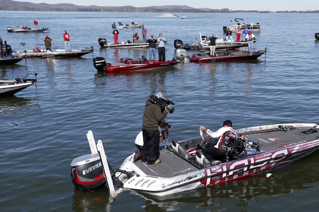Randall Tharp, Port Saint Joe, Fla., holds up a bass for spectators following him on the second day of the Bassmaster Classic, Saturday, Feb. 22, 2014, in Guntersville, Ala. Tharp was bumped from first to second by 1 ounce by Edwin Evers, Talala, Okla. The field will be cut to the top 25 anglers for the final day of competition. (AP Photo/Hal Yeager)