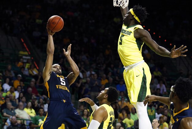 West Virginia guard Jaysean Paige, left, shoots past Baylor guard Ishmail Wainright and forward Johnathan Motley, right, in the first half of an NCAA college basketball game, Saturday, March 5, 2016, in Waco, Texas. (AP Photo/Rod Aydelotte)