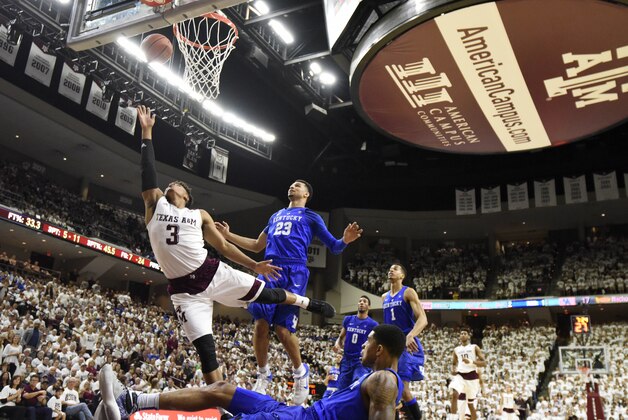Texas A&M's Admon Gilder (3) makes a basket as Kentucky's Tyler Ulis (3) falls to the ground during the first half of an NCAA college basketball game, Saturday, Feb. 20, 2016, in College Station, Texas. (AP Photo/Sam Craft)