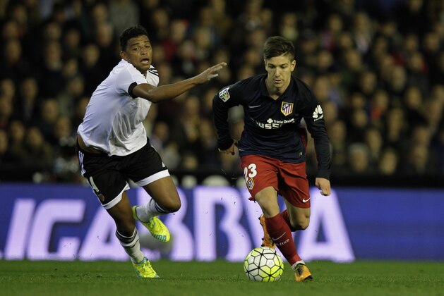 Valencia's Brazilian defender Aderlan Santos (L) vies with Atletico Madrid's Argentinian forward Luciano Vietto during the Spanish league football match Club Valencia CF vs Atletico de Madrid at Mestalla stadium in Valencia on March 6, 2016. / AFP / JOSE JORDAN        (Photo credit should read JOSE JORDAN/AFP/Getty Images)