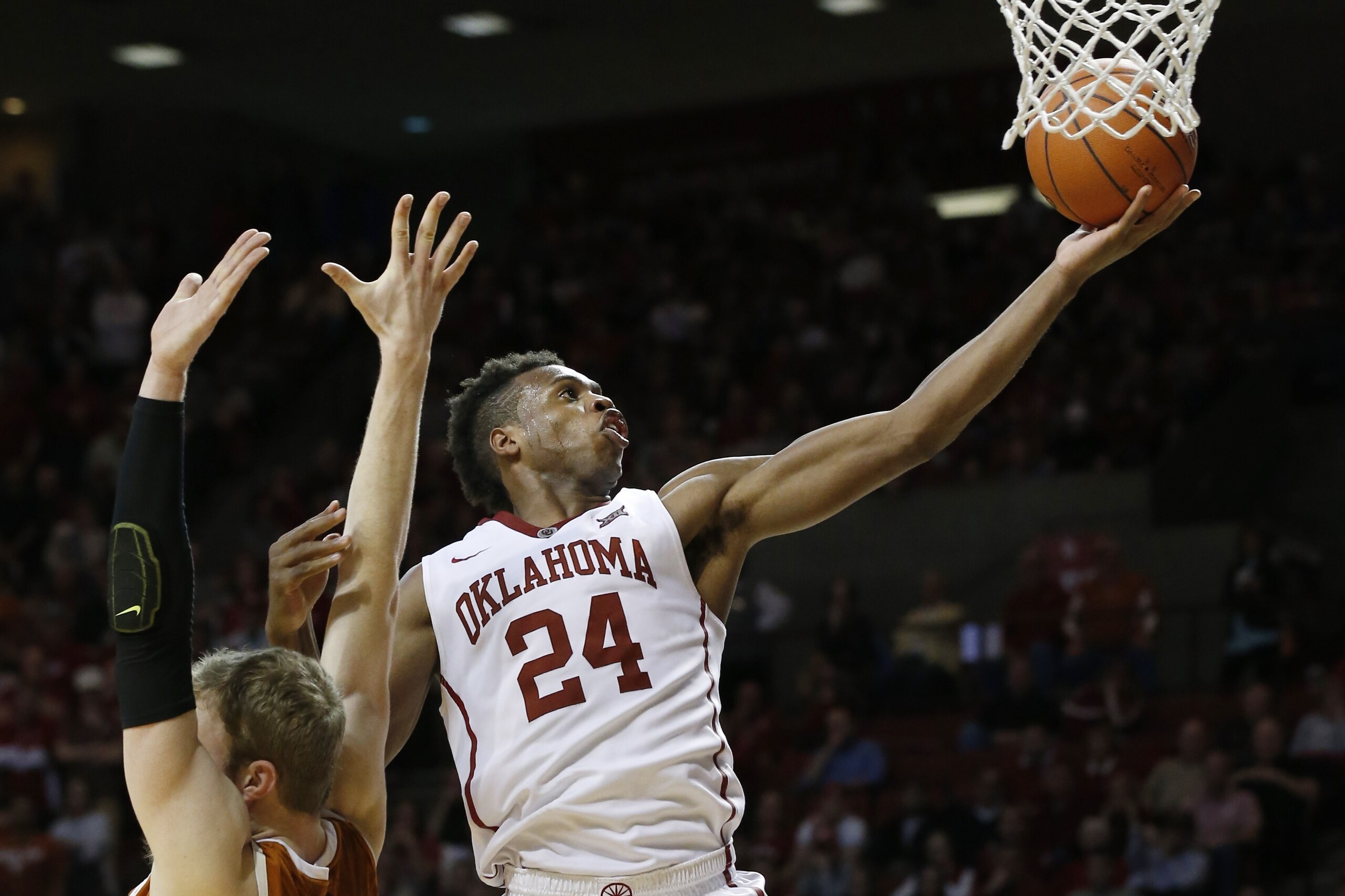 Oklahoma guard Buddy Hield (24) shoots behind Texas forward Connor Lammert, left, in the second half of an NCAA college basketball game in Norman, Okla., Monday, Feb. 8, 2016. Oklahoma won 63-60. (AP Photo/Sue Ogrocki)