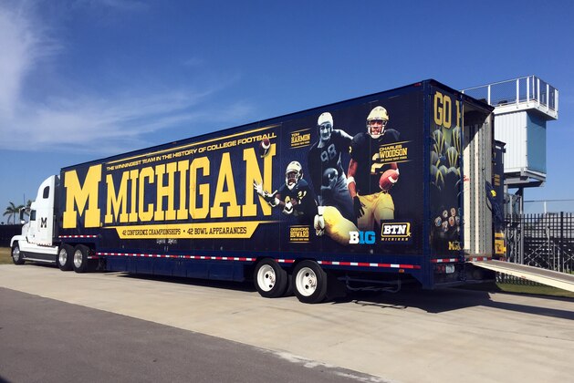A University of Michigan equipment truck is parked next to a practice field Tuesday, March 1, 2016, at IMG Academy in Bradenton, Fla. The Wolverines are spending a week at the boarding school for elite athletes, holding spring NCAA college football practice. (AP Photo/Ralph Russo)