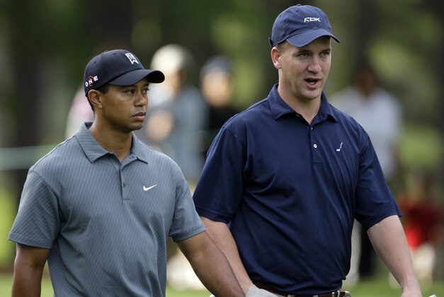 Tiger Woods, left, and Indianapolis Colts quarterback Peyton manning, right, talk as they walk down the third fairway during the pro-am of the Quail Hollow Championship golf tournament at the Quail Hollow Club in Charlotte, N.C., Wednesday, April 29, 2009. (AP Photo/Chuck Burton)