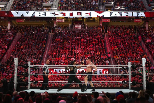 WWE wrestler Roman Reigns throws a punch at Brock Lesnar at Wrestlemania XXXI, on Sunday, March 29, 2015 in Santa Clara, CA. 2015 marks the first year Wrestlemania will be held in the San Francisco Bay Area, being made available to viewers in 177 countries via the WWE Network. (Don Feria/AP Images for WWE)